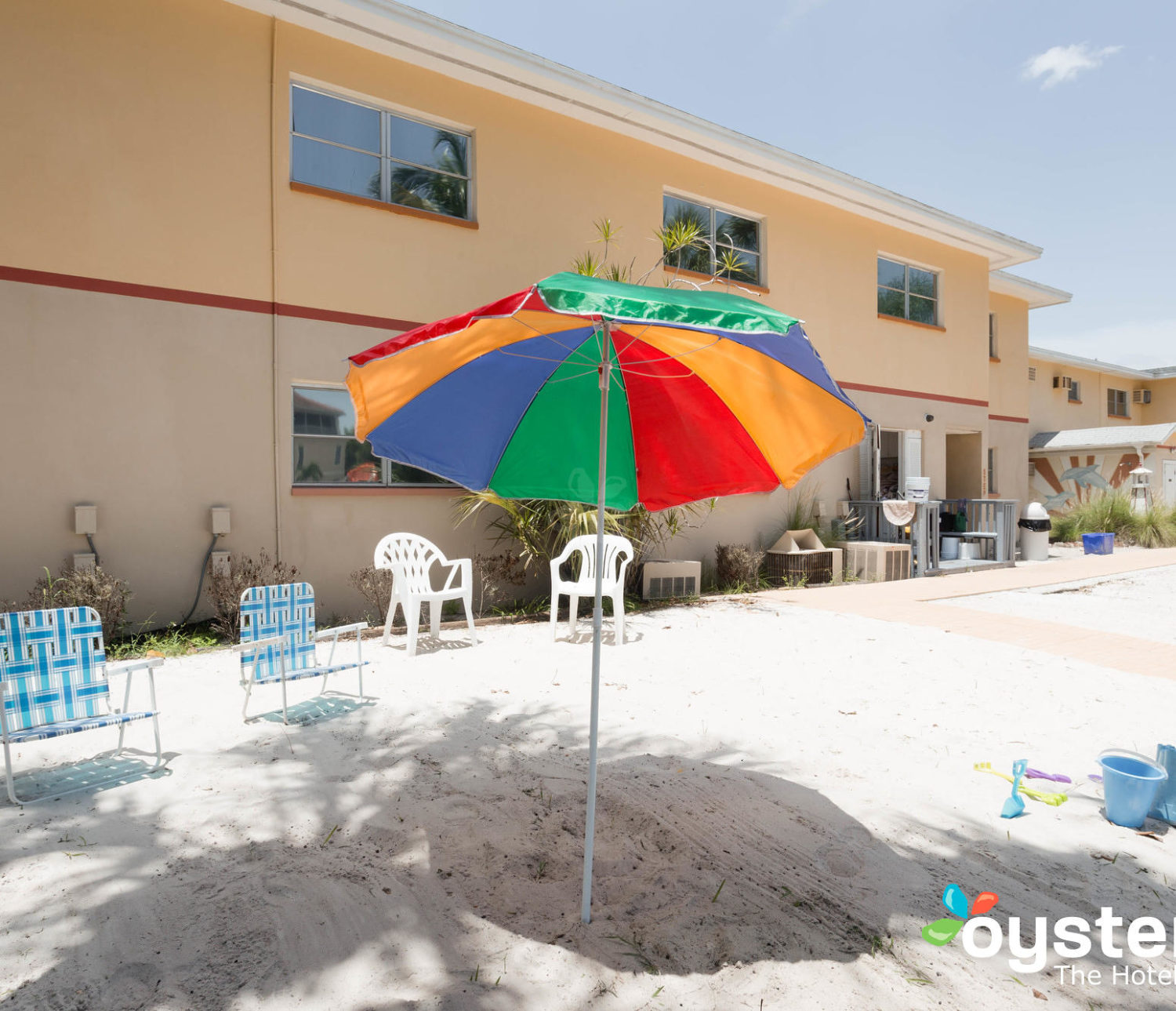 Hideaway Hotel - beach view with umbrella and building