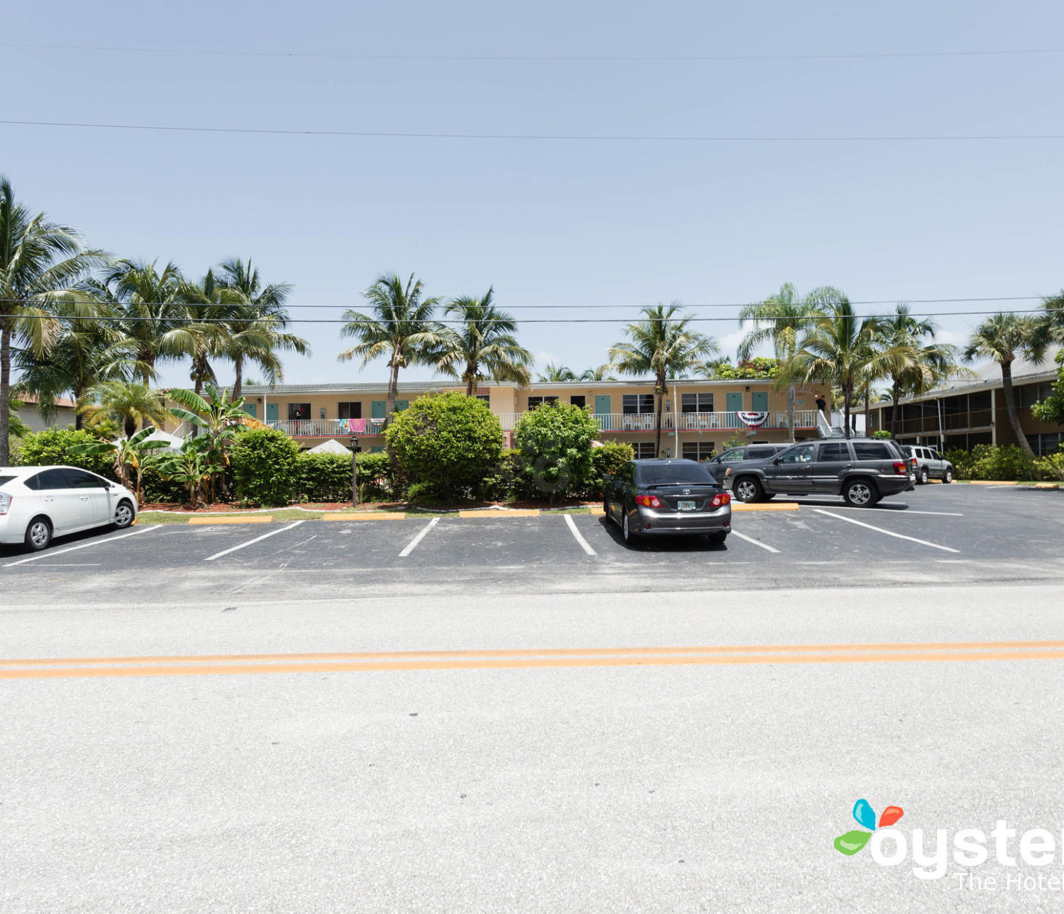 Hideaway Hotel - parking lot view of building with palm trees