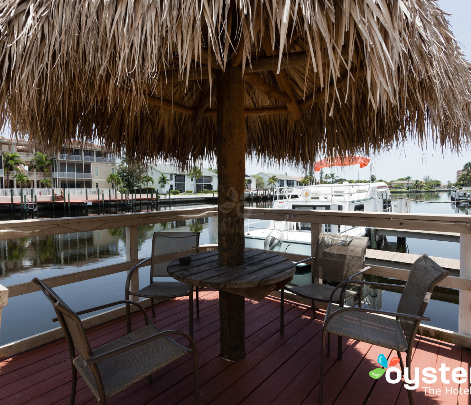 Hideaway Hotel - under the tiki hut, view of canal from dock with seating area and moored boats